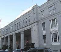 Facade of a large white building, the left having large pillars 