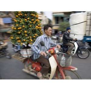  A Vietnamese Vendor Races Down a Street on a Motorbike 